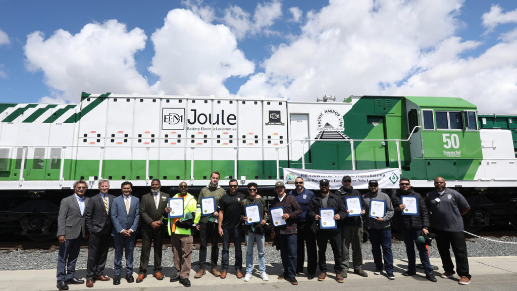 FRA Administrator Amit Bose, Anacostia Rail Holdings executives, and ports of Los Angeles and Long Beach officials on May 4 gathered to celebrate PHL’s latest group of locomotive engineer graduates to serve the San Pedro Port complex. They stand in front of Progress Rail’s zero-emission, zero-idle EMD® Joule battery-electric locomotive, which recently arrived to begin a year of railroad testing. (Photograph Courtesy of The Wolcott Group)