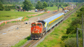A CN train is viewed passing the Milton Intermodal Terminal construction site in July 2023 as crews work to extend the "CN Ash" control point in preparation for the Terminal. The train pictured is CN delivering a new Siemens Venture trainset to VIA Rail in Montreal. (Caption and Photograph Courtesy of Stephen C. Host)