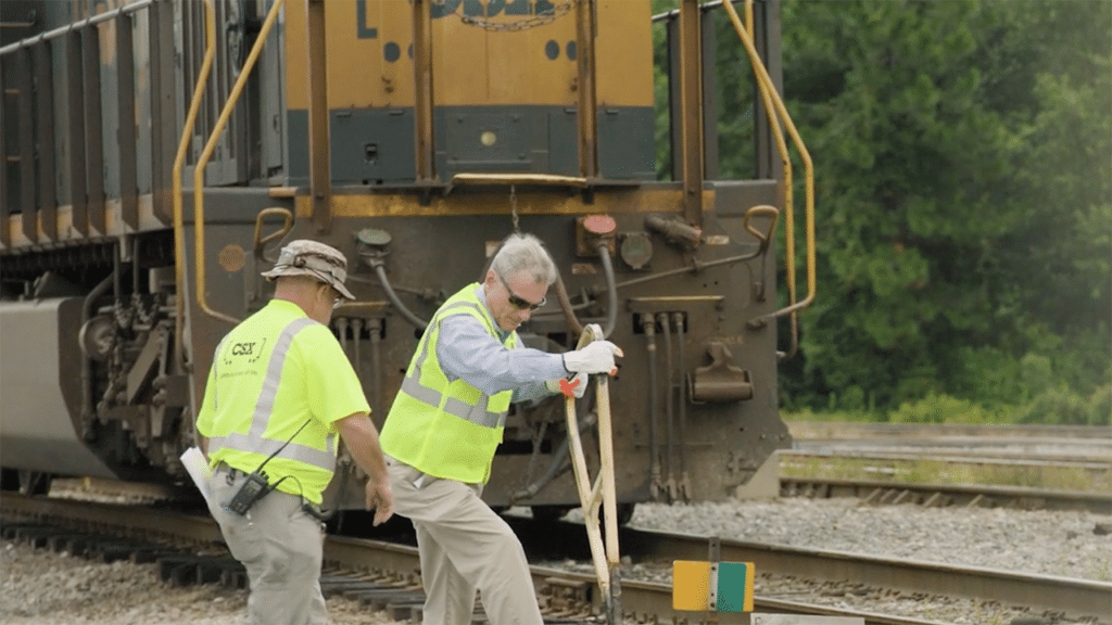 CSX educated Rep. Buddy Carter (R-Ga.) on what it’s like to be a railroader during his visit to the Southover Yard in Savannah, Ga.—including how to throw a switch. Carter is pictured (right) with CSX Conductor Kevin Cook. (Screen Shot of CSX Video)