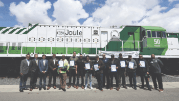 FRA Administrator Amit Bose, Anacostia Rail Holdings executives, and ports of Los Angeles and Long Beach officials on May 4, 2023, gathered to celebrate PHL’s latest group of locomotive engineer graduates to serve the San Pedro Port complex. They stand in front of Progress Rail’s zero-emission EMD® Joule battery-electric locomotive. Since this photograph was taken, PHL has been operating the locomotive for one year. (Photograph Courtesy of The Wolcott Group)