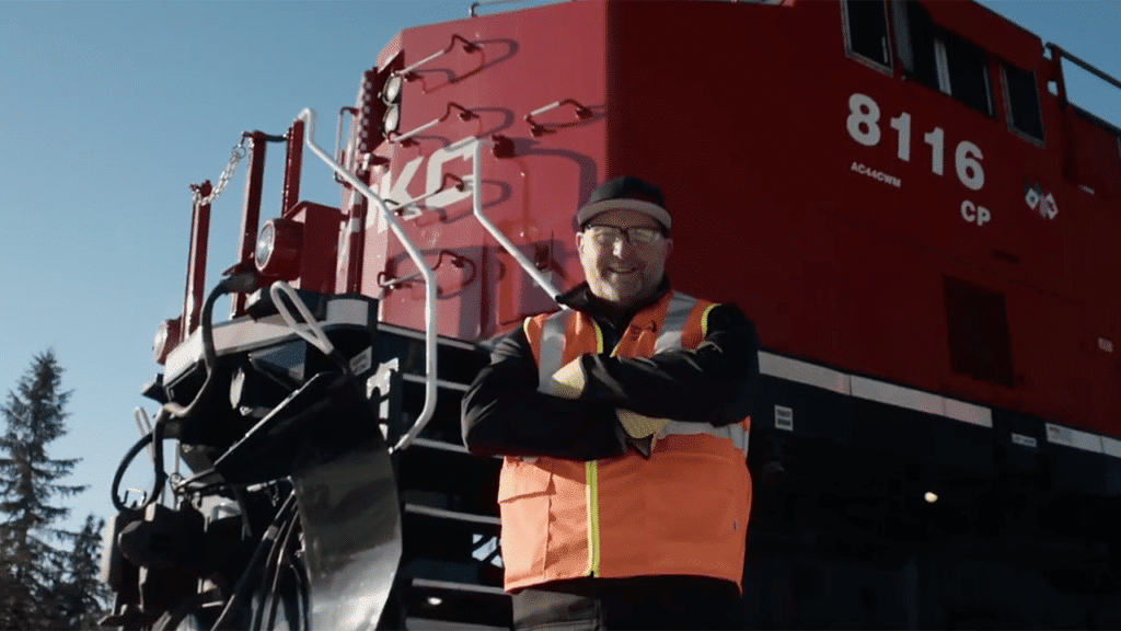 Darryl Perry, a CPKC locomotive engineer in Sparwood, B.C., Canada, is one of the 200-plus “CPKC Hypermilers” who the railroad said “use their ‘feel’ for a locomotive and in-depth local knowledge, coupled with fuel-efficient strategies, to operate trains safely while reducing excess fuel burn.” (Screen Grab from CPKC Video)